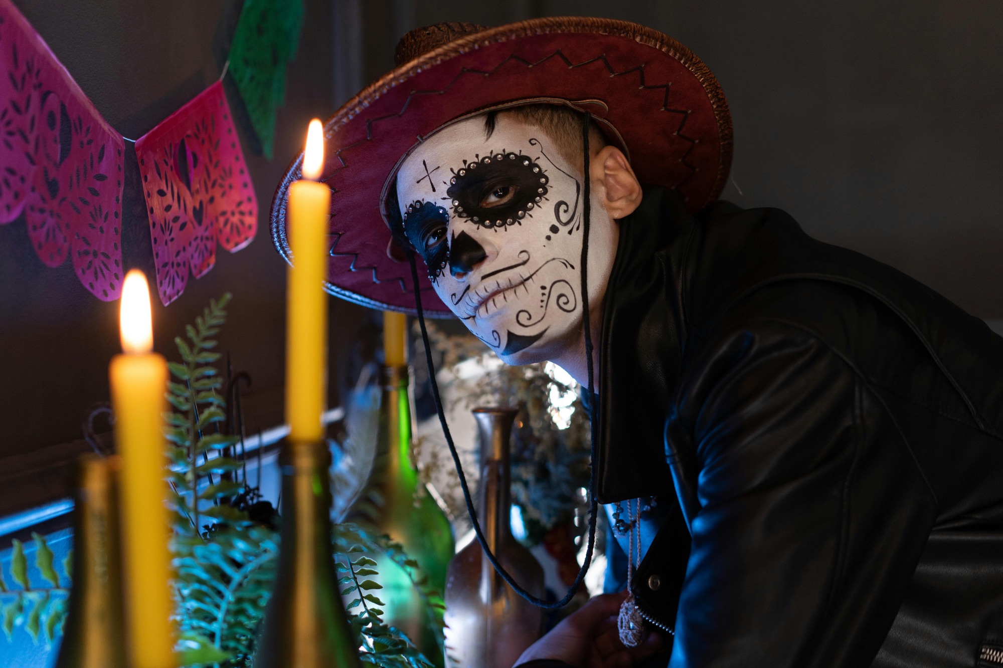 A man in dia de los muertos makeup looking at the camera.